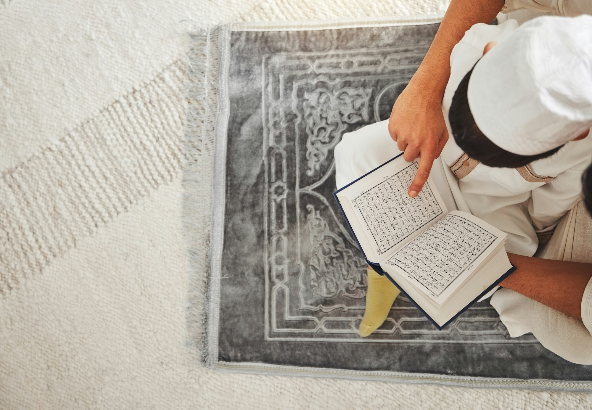 Quran, Islam child and parent on floor reading for religion learning, muslim pray and faith in Alla