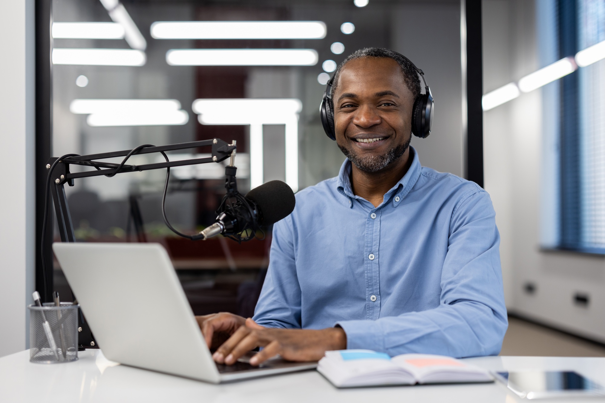 Mature African American businessman records educational business course video with a microphone and