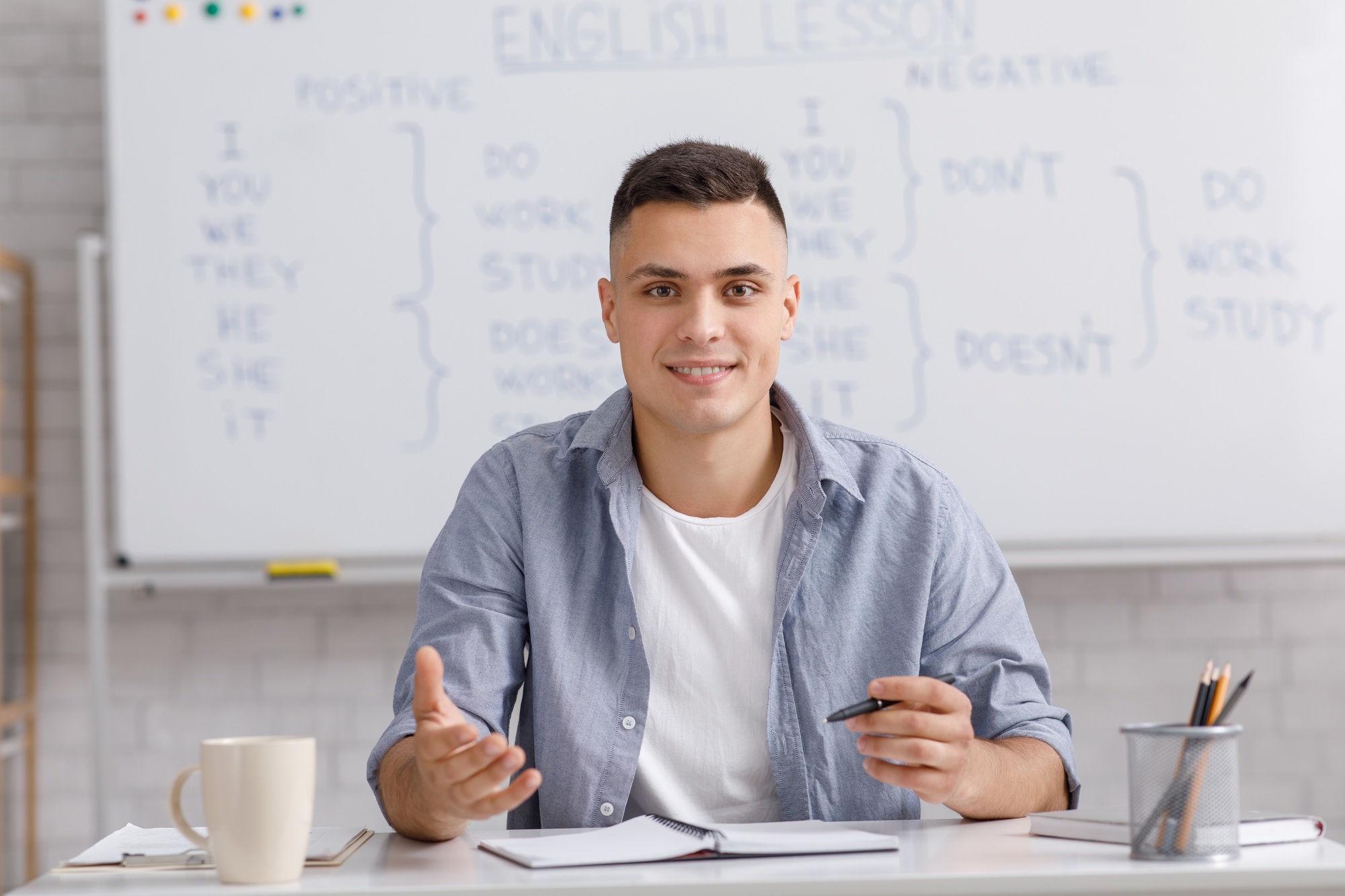 Online teacher speaking by webcam, sitting at table in home office and explaining rules english