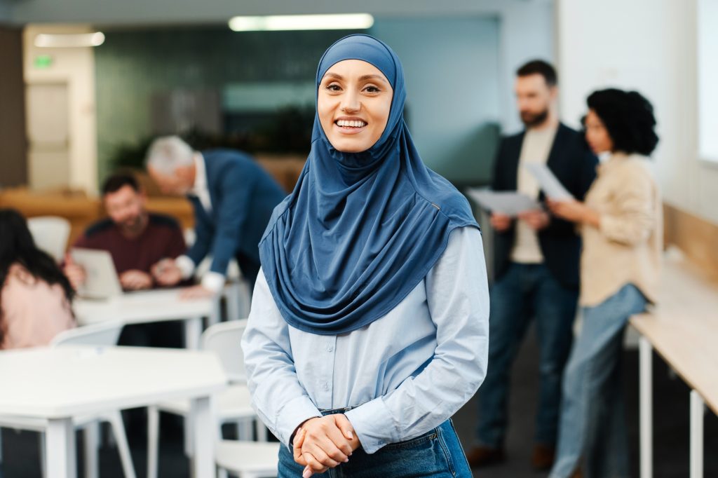 Portrait of beautiful smiling Arab woman wearing hijab, looking at camera